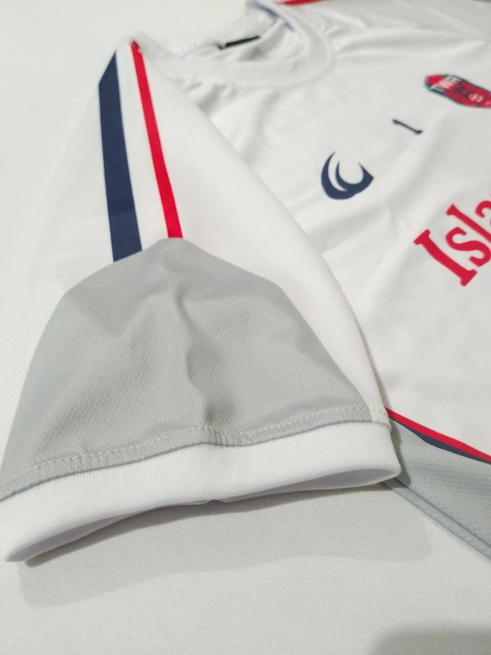 The contrast red and navy trim on the sleeve of the white away shirt