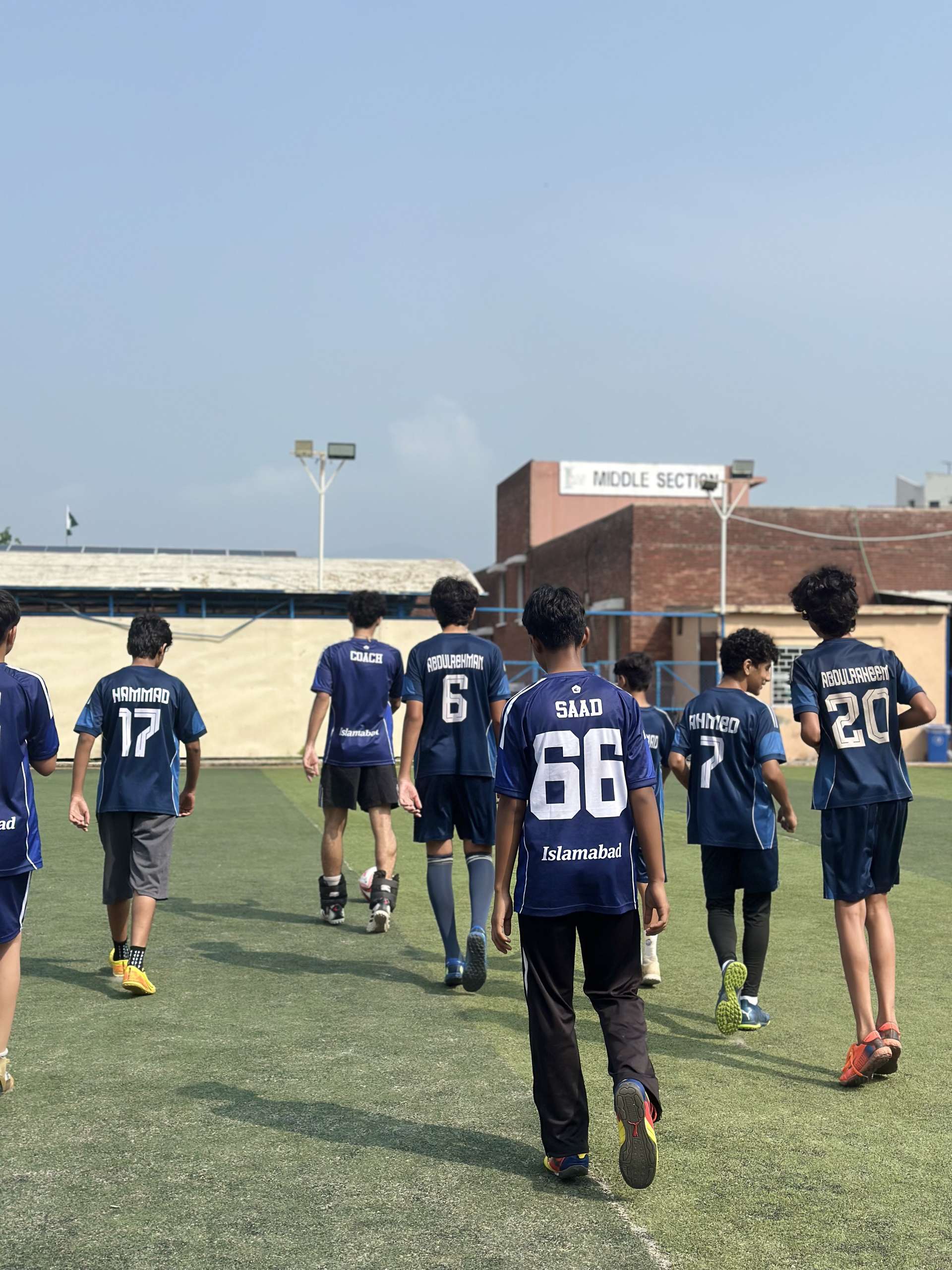 The squad walking away across the pitch at the end of training