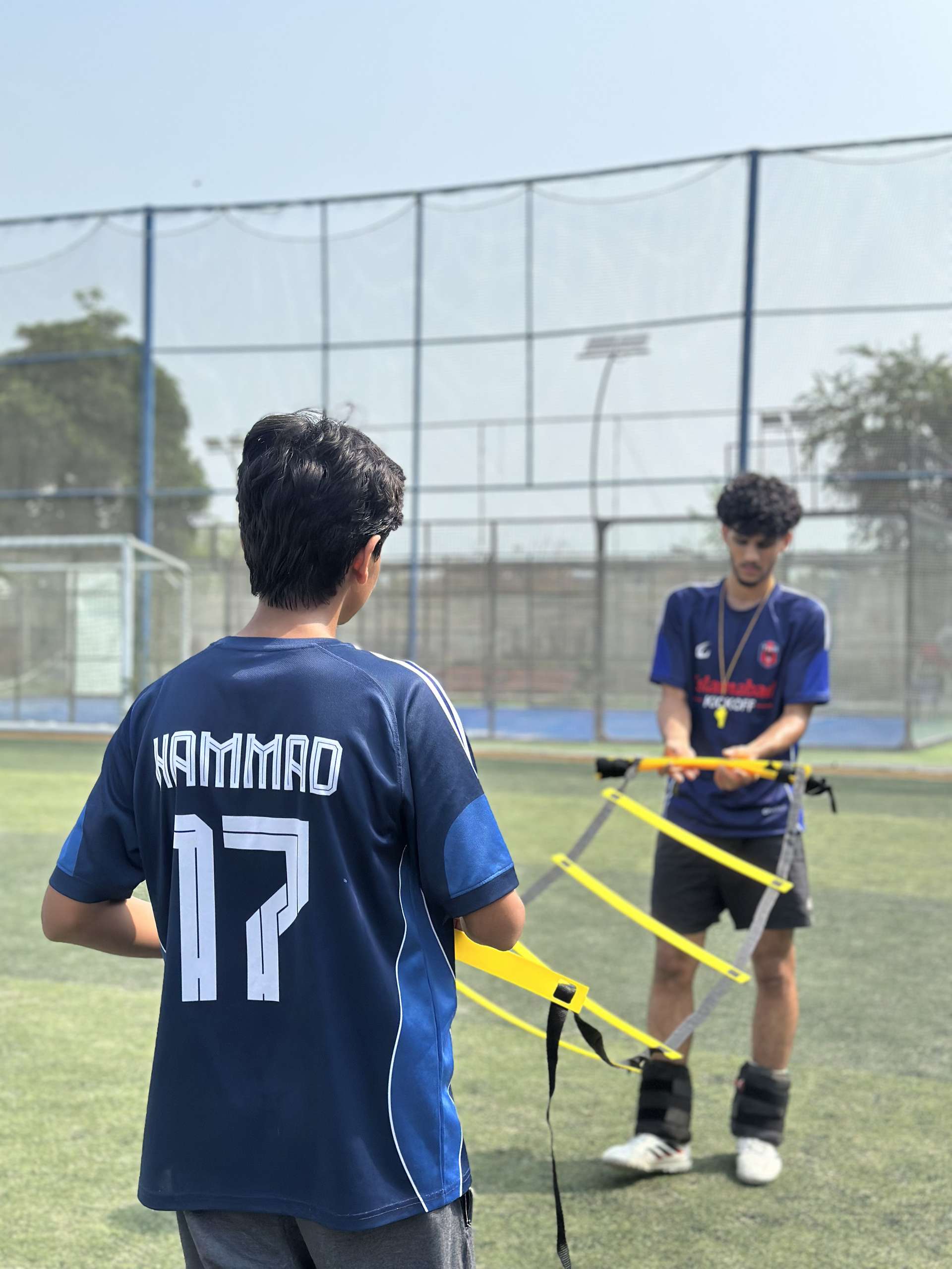 A coach counting a player through a ladder drill at training